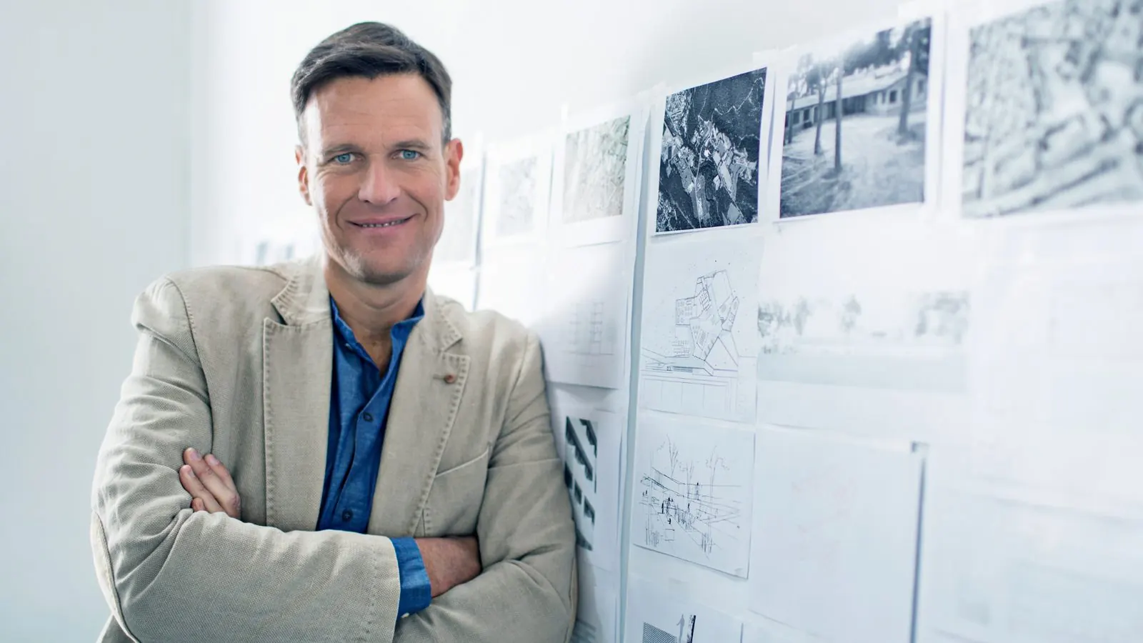 Ing&eacute;nieur devant un mur de plans et de croquis techniques