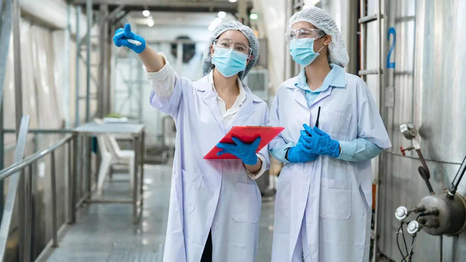 Deux techniciennes qualité en tenue d'hygiène inspectant une ligne de production agroalimentaire, presse-papier à la main, dans le contexte d'un audit IFS/BRC