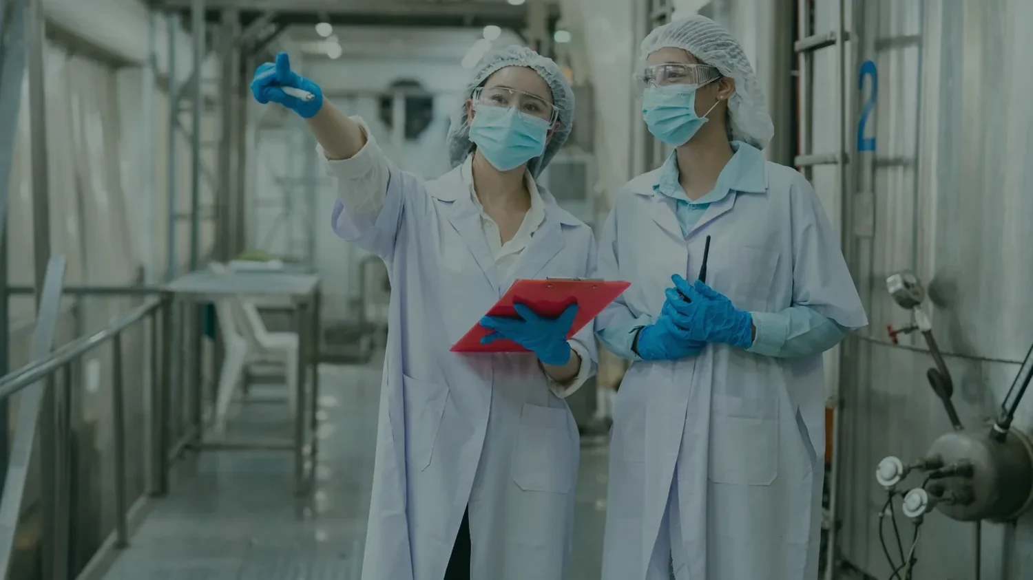 Responsable qualité en tenue d'hygiène révisant le plan de maîtrise sanitaire dans un atelier de production agroalimentaire